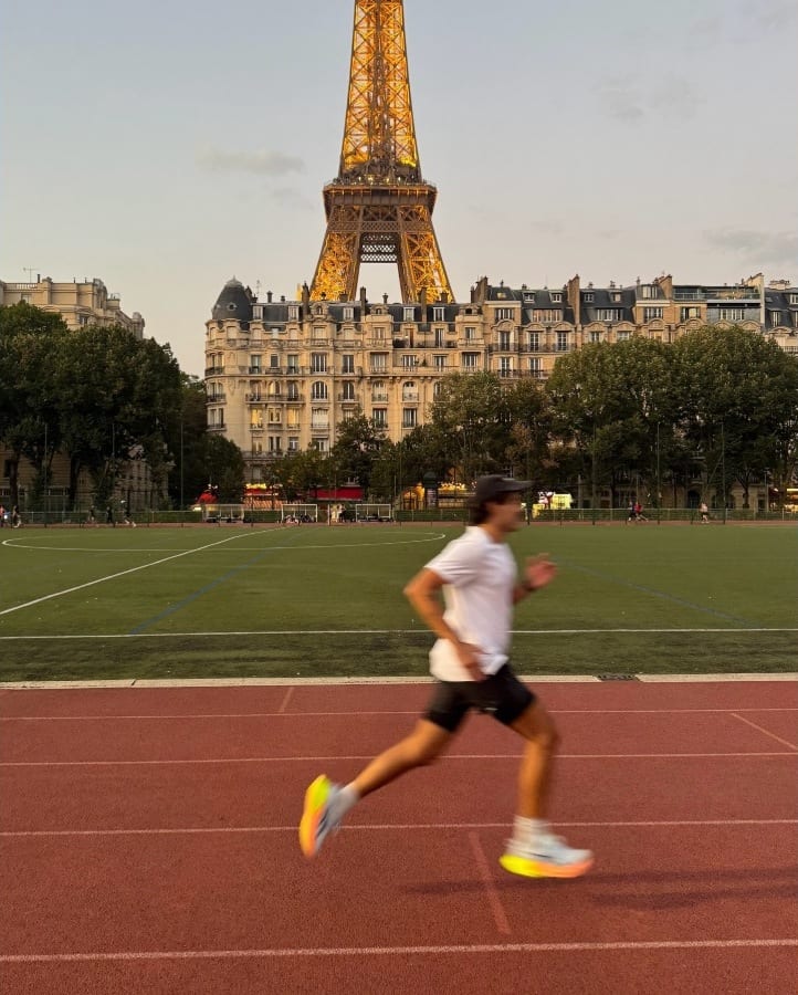 O Lucas a correr numa pista, com a Torre Eiffel ao fundo.